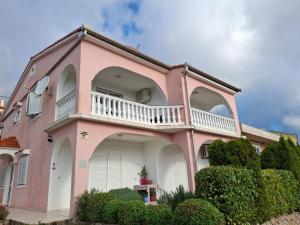 een roze huis met een balkon bij Blue Ivy App Salatić Besplatno korištenje električnih bicikala in Vrh