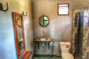 ein Badezimmer mit einem WC, einem Waschbecken und einem Spiegel in der Unterkunft Above The Sea Maesariang in Mae Sariang