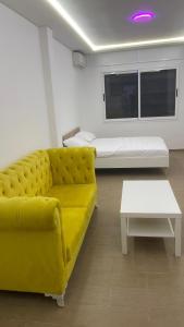 丹吉尔Mirasol achakar的客厅里有一张黄色沙发和一张床