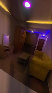 un soggiorno con un divano giallo e luci viola di Mirasol achakar a Tangeri Altre 22 foto