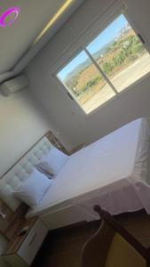 丹吉尔Mirasol achakar的有窗户的房间里有一张大床 更多22张照片