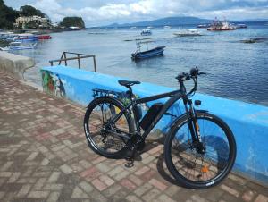 a bike parked against a blue wall next to the water at Villa Bor a Mar - Holiday homes in Puerto Galera