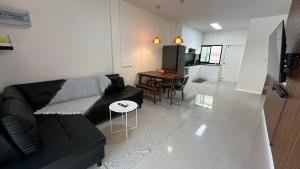 een woonkamer met een zwarte bank en een tafel bij Holiday home in Ban Na Khua