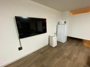a white room with a television and a refrigerator at 民宿一休 in Otaru