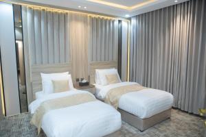 沙鲁拉بن سنكر لشقق المخدومة的带窗户的酒店客房内的两张床