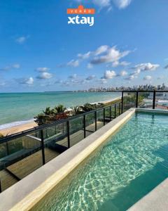 een zwembad op het balkon van een appartement met uitzicht op het strand bij Restinga by Xtay - Studios pé na areia, com piscina na cobertura e comércios ao redor in João Pessoa