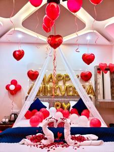 a room with a bed with red hearts and balloons at Hotel The Pushpraj in Varanasi