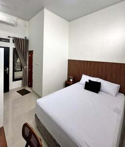 a bedroom with a large white bed in a room at Nuwo Adin Syariah Guest House in Tanjungkarang
