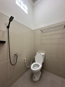 a bathroom with a toilet and a shower at Nuwo Adin Syariah Guest House in Tanjungkarang