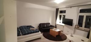 a living room with a couch and a chair at Central Apartments Chemnitz KASSBERG in Chemnitz
