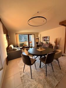 a living room with a table and chairs at SixT Lodge in Saint-Jean-de-Sixt