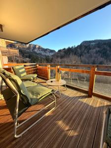 a deck with chairs and a table on a boat at SixT Lodge in Saint-Jean-de-Sixt