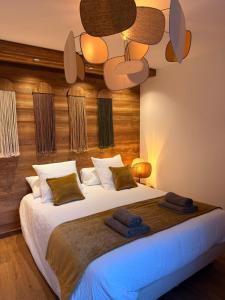a bedroom with a large bed with a ceiling at SixT Lodge in Saint-Jean-de-Sixt