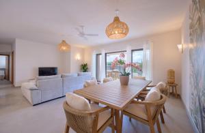 een woonkamer met een houten tafel en stoelen bij Résidence ORYAM B21 in Pointe aux Biches