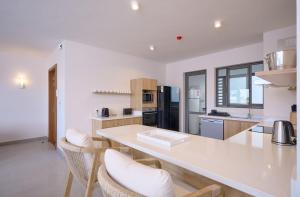 een keuken met een grote witte tafel en stoelen bij Résidence ORYAM B21 in Pointe aux Biches