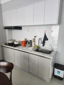 een keuken met witte kasten en een spoelbak bij Haven Place 254 in Nairobi