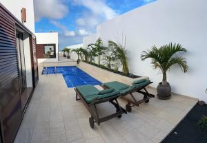 una piscina con due sedie a sdraio accanto a una casa di CuevaBlanca a Güime