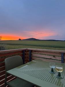 een tafel met twee glazen witte wijn op een balkon bij Ferienhaus Frankenzeit in Westheim