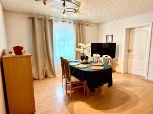 a dining room with a table with chairs and a television at Haus noe in Kehl am Rhein