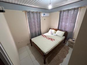 a small bed in a small room with curtains at C's Sunrise Escape in Roseau