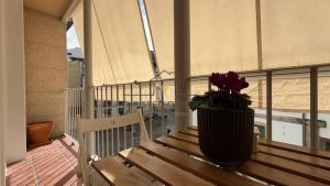 a vase sitting on a wooden bench on a balcony at Calpurnia Casco Viejo in Ourense