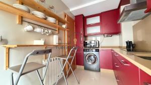 a kitchen with red cabinets and a washer and dryer at Calpurnia Casco Viejo in Ourense