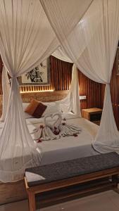 a bed with white drapes on top of it at Asri Sari Ubud Resort in Ubud +48 photos