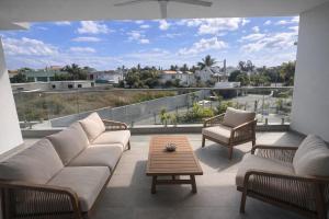 een woonkamer met een bank, stoelen en een tafel bij Résidence ORYAM B21 in Pointe aux Biches