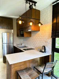 a kitchen with a counter with chairs and a refrigerator at Modern Condo in Nimman 501 in Chiang Mai +19 photos