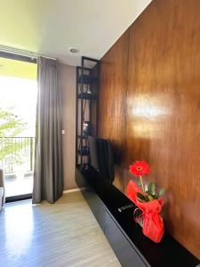 een woonkamer met een muur waarop een tv en een rode bloem staan bij Modern Condo in Nimman 501 in Chiang Mai +19 foto's