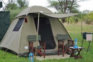 a tent with chairs and a table in a field at Twende Africa Tours in Moshi