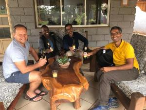a group of men sitting around a table drinking beer at Twende Africa Tours in Moshi