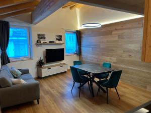 a living room with a table and chairs and a television at Casa Franz in Tesero