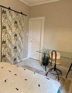 a room with a glass table and a chair at La Parenthèse Champenoise in Épernay +5 photos