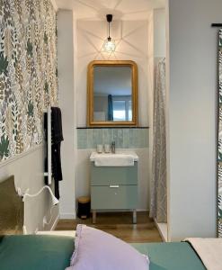 een badkamer met een wastafel en een spiegel bij La Parenthèse Champenoise in Épernay +15 foto's