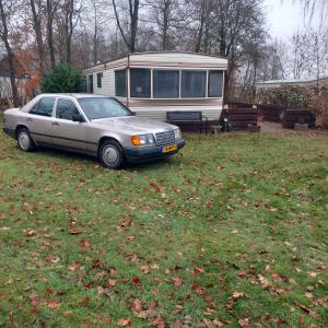 een auto geparkeerd in het gras voor een huis bij Stacaravan Camping It Wiid Earnewoude in Earnewâld