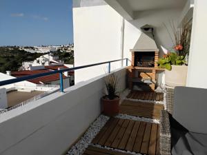 a balcony with wooden stairs and a fire place at LUXURY OCEAN PENTHOUSE- panoramic sea view & tikki bar on private terrasse in Luz +67 photos