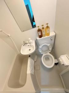ein kleines Badezimmer mit Toilette und Waschbecken in der Unterkunft Katsu hotel 3号一室一厅 in Osaka + 16 Fotos