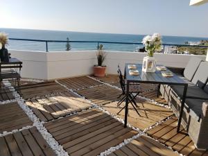 a patio with a table and a view of the ocean at LUXURY OCEAN PENTHOUSE- panoramic sea view & tikki bar on private terrasse in Luz
