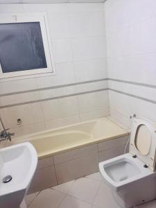 a bathroom with a toilet and a tub and a sink at Sryia 1 in Sharjah
