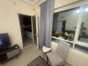 a living room with a chair and a window at Sryia 1 in Sharjah