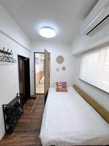 ein Schlafzimmer mit einem großen Bett mit Fenster in der Unterkunft Katsu hotel 3号一室一厅 in Osaka