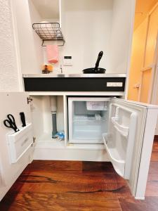 eine Küche mit Spüle und offenem Kühlschrank in der Unterkunft Katsu hotel 3号一室一厅 in Osaka