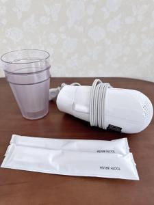 Eine Flasche Milch und ein Becher Wasser auf einem Tisch in der Unterkunft Katsu hotel 3号一室一厅 in Osaka