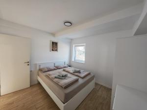 a bedroom with a bed in a white room at Apartments Pronavtik in Piran