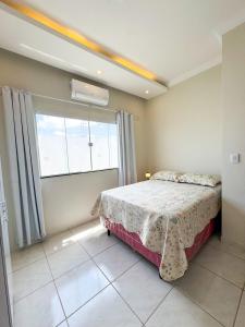 a bedroom with a bed and a large window at Casa Vitória-régia in Camocim