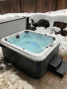 une baignoire jacuzzi avec de la neige au sol dans l'établissement Spa - Foosball Table - Le Floriska, à Stoneham