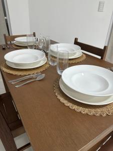 un tavolo in legno con piatti e bicchieri bianchi di Raices del Parana a Puerto Rico 1 altra foto