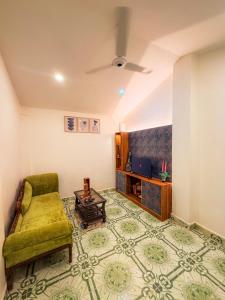 ein Wohnzimmer mit einer grünen Couch und einem Tisch in der Unterkunft Traverse Homes Palolem in Canacona + 4 Fotos