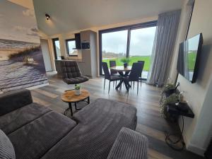 een woonkamer met een bank en een tafel bij Chalet aan het water in Sprong